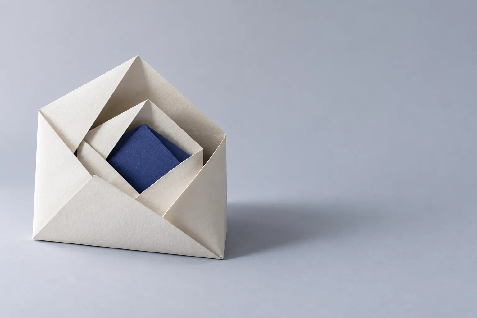 Layered sheets of paper nested inside each other, the innermost one indigo